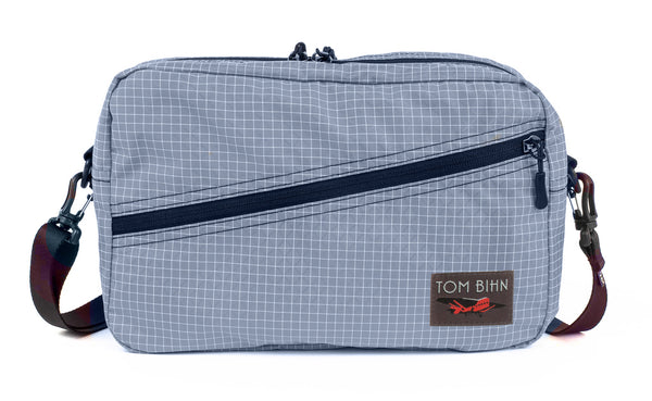 A Packing Cube Shoulder Bag in Northwest Sky (light grey with white grid) 200 Halcyon with a 1-inch shoulder strap attached.